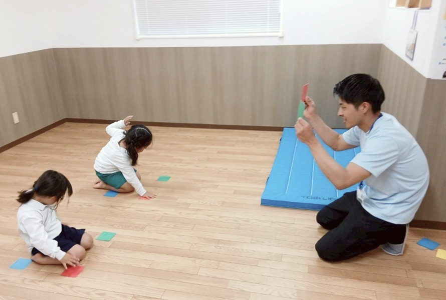 保育者と一緒に運動遊びをする子供